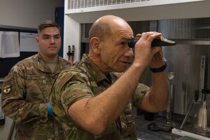 U.S. Air Force Staff Sgt. Anthony Ditonno, 733rd Logistics Readiness Squadron fuels distribution operator, presents fuels laboratory equipment to Gen. Mike Holmes, the commander of Air Combat Command, at Joint Base Langley-Eustis, Virginia, Feb. 7, 2020.