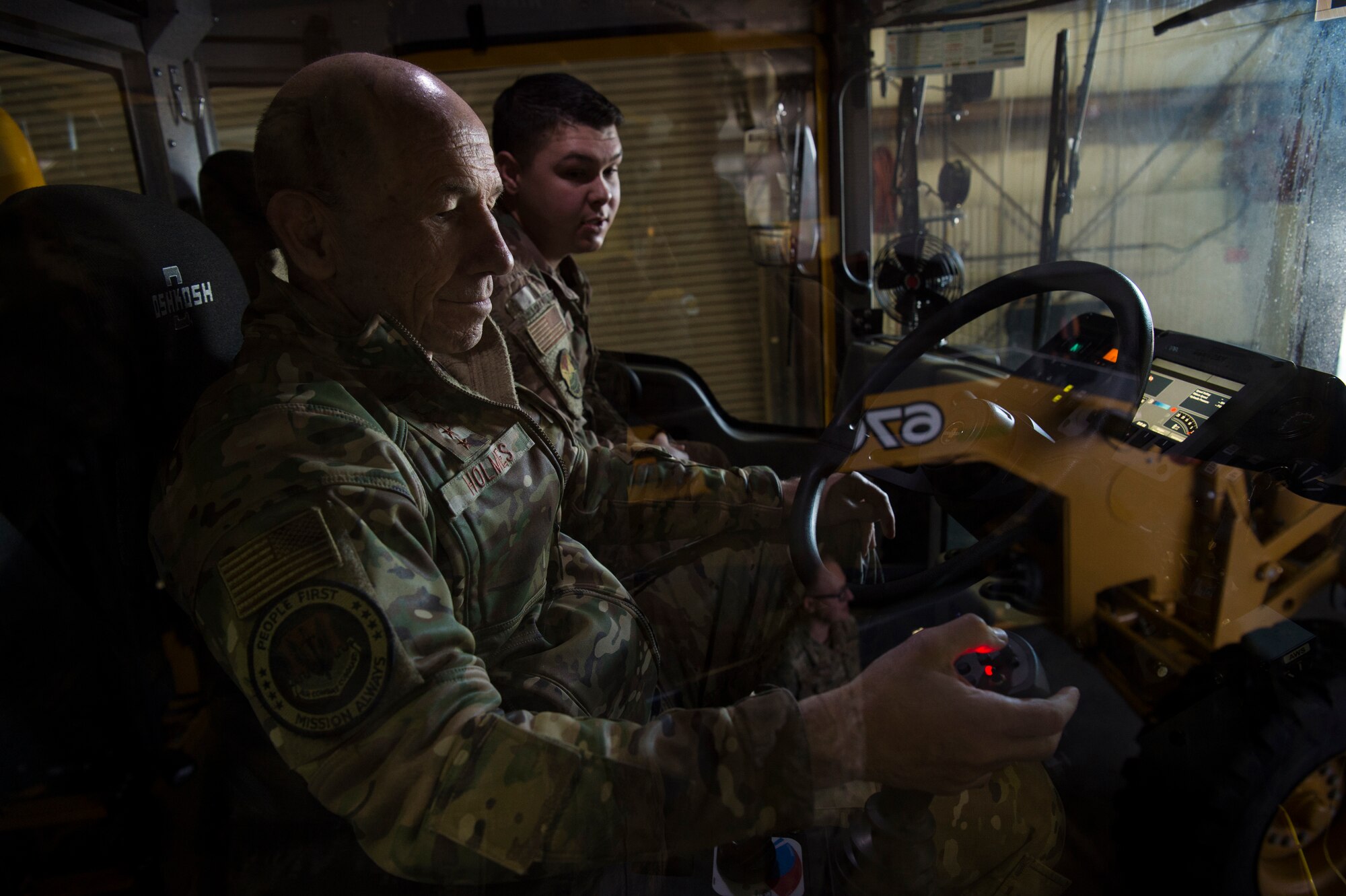 U.S. Air Force Senior Airman Bradford Frint, 633rd Civil Engineer Squadron pavements and equipment journeyman, demonstrates how to operate a snow plow to Gen. Mike Holmes, the commander of Air Combat Command at Joint Base Langley-Eustis, Virginia, Feb. 7, 2020.