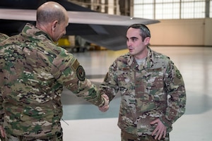 U.S. Air Force Gen. Mike Holmes, commander of Air Combat Command, presents a coin to Staff Sgt. Thomas Watt, 27th Fighter Squadron avionics systems craftsman, at Joint Base Langley-Eustis, Virginia, Feb. 6, 2020.