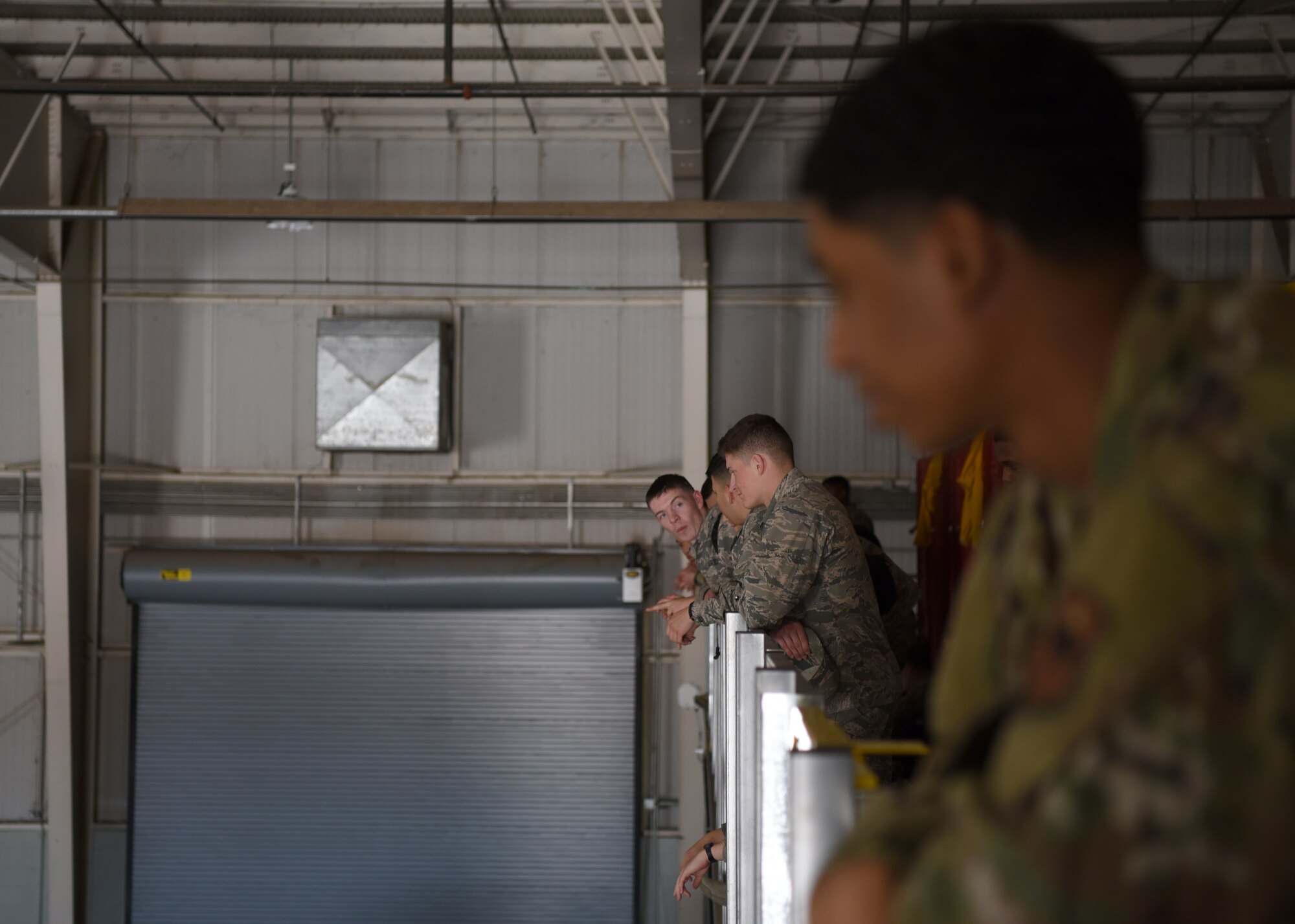 U.S. Air Force students from the 17th Training Wing claim their spot to view the 17th Training Group Drill Competition inside the Louis F. Garland Department of Defense Fire Academy High Bay on Goodfellow Air Force Base, Texas, Feb. 7, 2020. The elevated platform provides a bird’s eye view of the competition. (U.S. Air Force photo by Airman 1st Class Abbey Rieves)