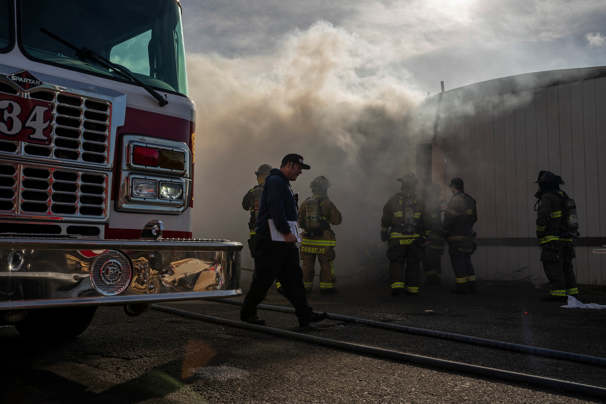 Firefighters from various local fire emergency services participate in a live burn training at Travis Air Force Base, California, Jan. 14, 2020. Travis Fire Emergency services and 10 other fire departments used four buildings at Travis AFB for live-fire training before conducting a final controlled burn to remove them. (Courtesy photo)