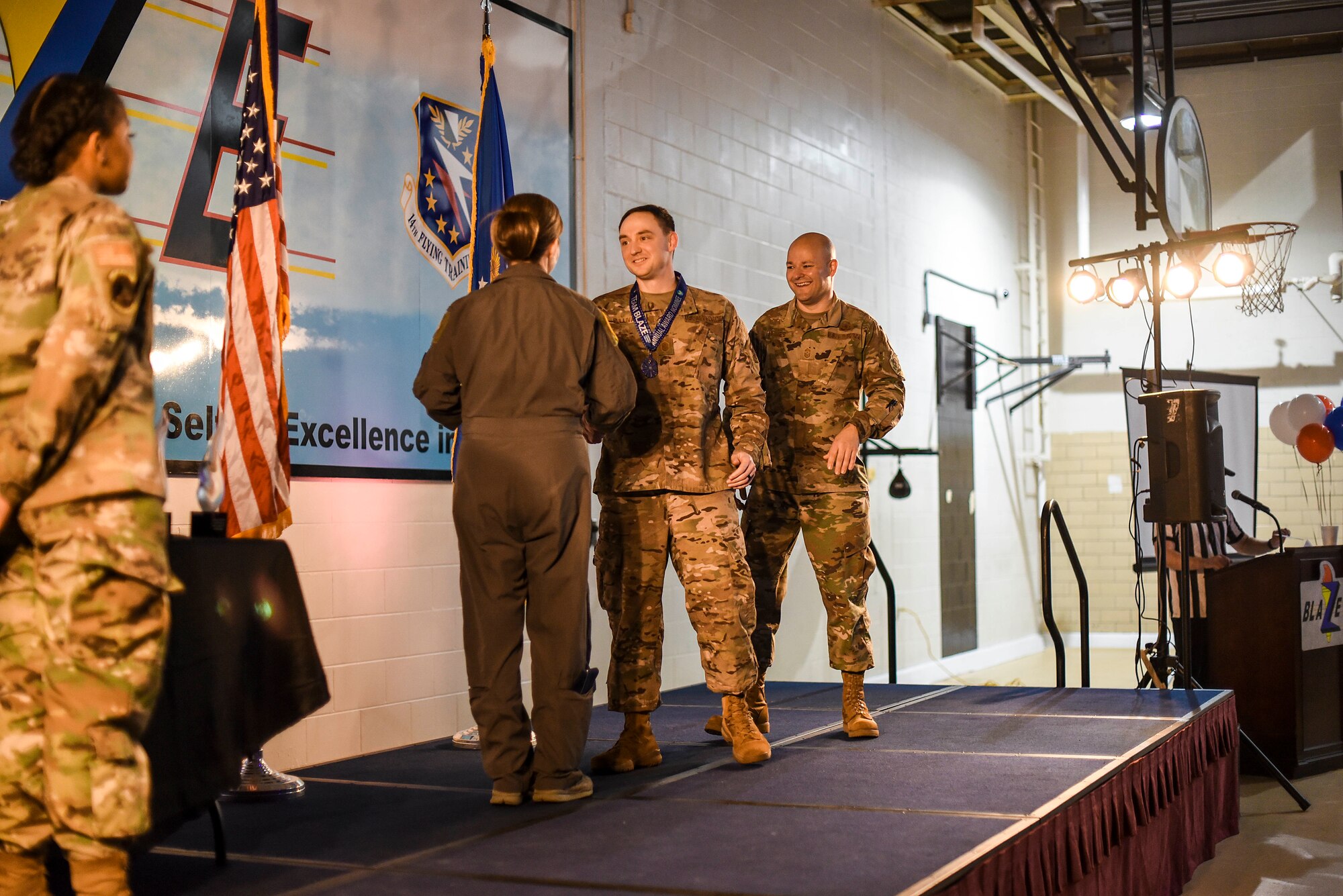 Col. Samantha Weeks, 14th Flying Training Wing commander, and Chief Master Sgt. Trevor James, 14th FTW command chief, congratulate Master Sgt. Nathan Sullivan, 14th Operations Group first sergeant, after winning the First Sergeant of the Year award Feb. 9, 2020, on Columbus Air Force Base, Miss. Every nominee was presented a medal before the ceremony and every winner was presented with an official trophy during the ceremony. (U.S. Air Force photo by Senior Airman Keith Holcomb)