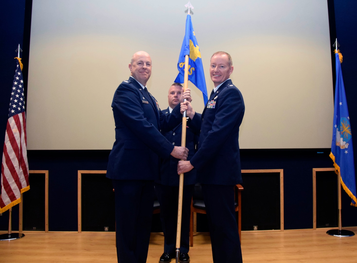 Col. James C. “JC” Miller, 433rd Operations Group commander, presents the guidon to Lt. Col. Douglas P. Schoenenberger, 68th Airlift Squadron commander, during an assumption of command ceremony at Joint Base San Antonio-Lackland, Texas, Feb. 8, 2020.