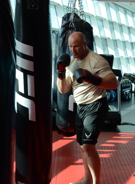 A special warfare Airmen does some training on a punching bag during a workout with an Ultimate Fighting Championship fighter as part of video production at the UFC Performance Institue in Las Vegas,