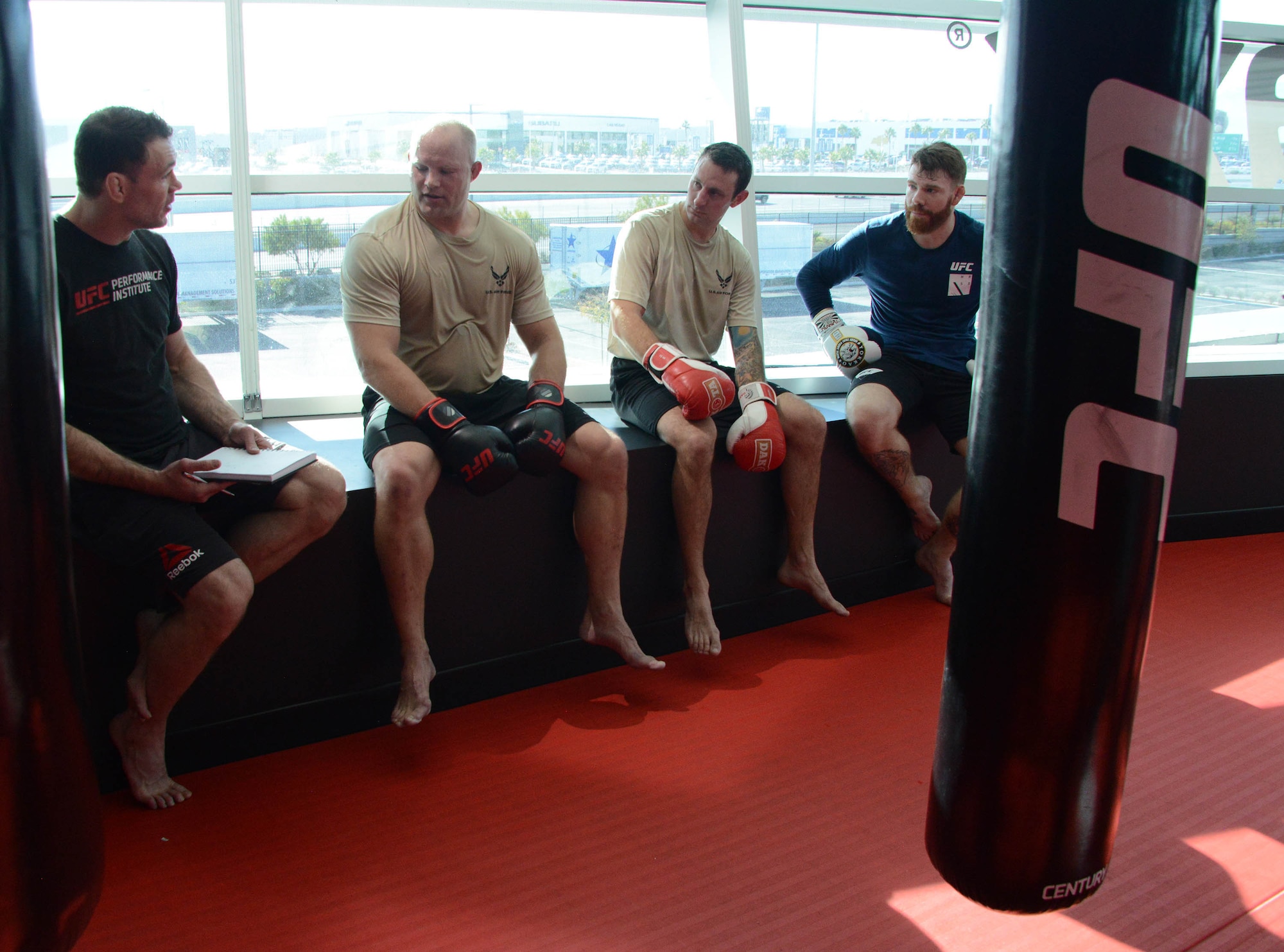 Special warfare Airmen and UFC fighters Forrest Griffin (left) and Paul Felder (right) discuss their workout during a production at the Ultimate Fighting Championship Performance Institute in Las Vegas, Nevada.