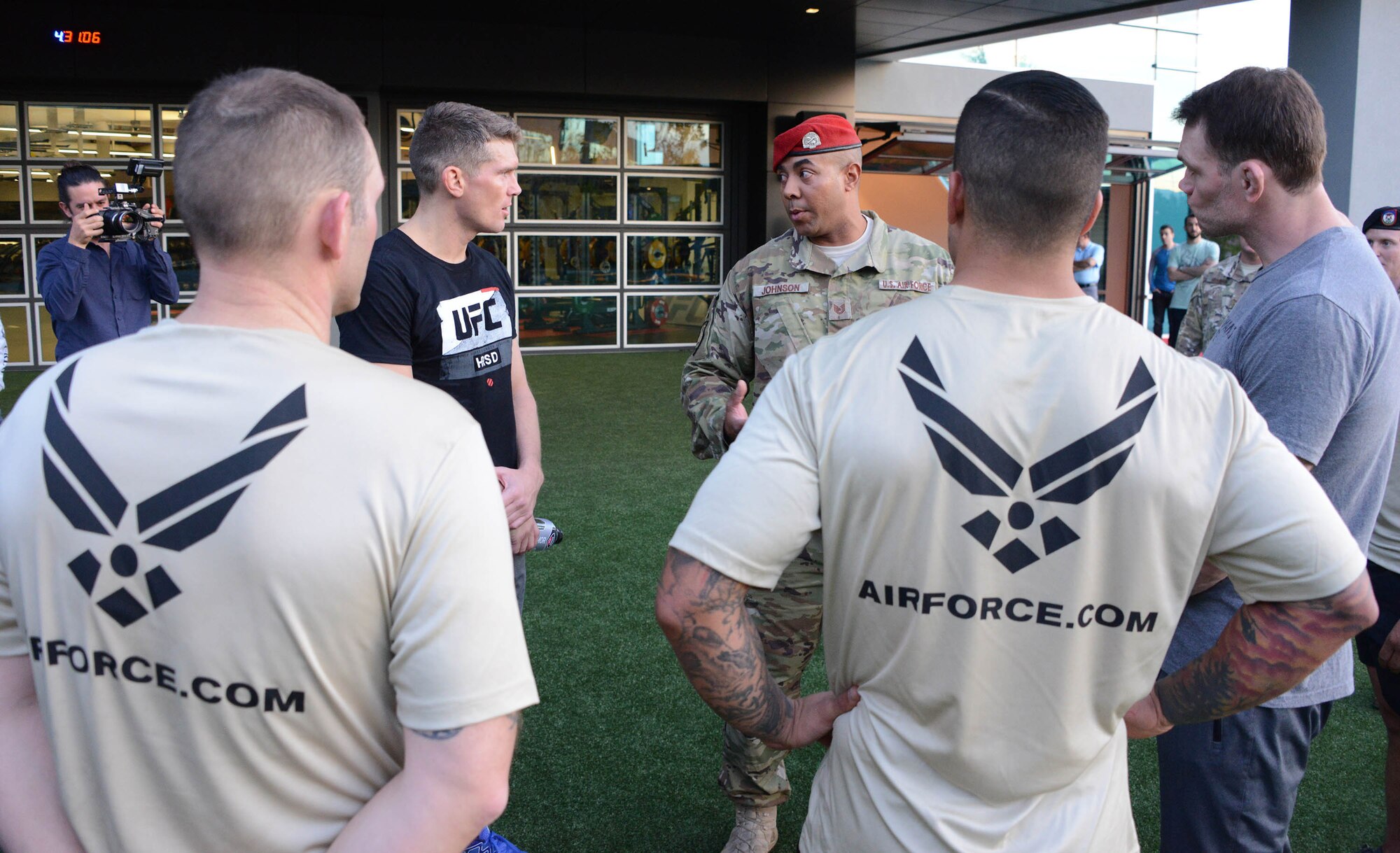 Tech. Sgt. Will Johnson, 330th Recruiting Squadron, gives instructions on how to perform special warfare memorial push-ups to Ultimate Fighting Championship fighters Forrest Griffin and Stephen Thompson during a production at the UFC Performance Institute in Las Vegas,