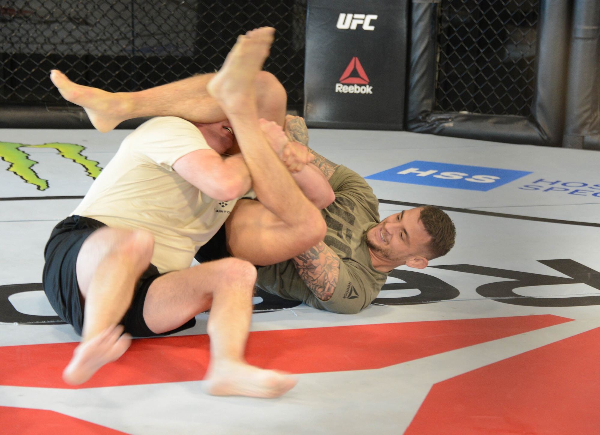 Ultimate Fighting Championship fighter Dustin Poirier conducts some grappling moves with a special warfare Airman as part of a film production at the UFC Performance Institute in Las Vegas, Nevada.