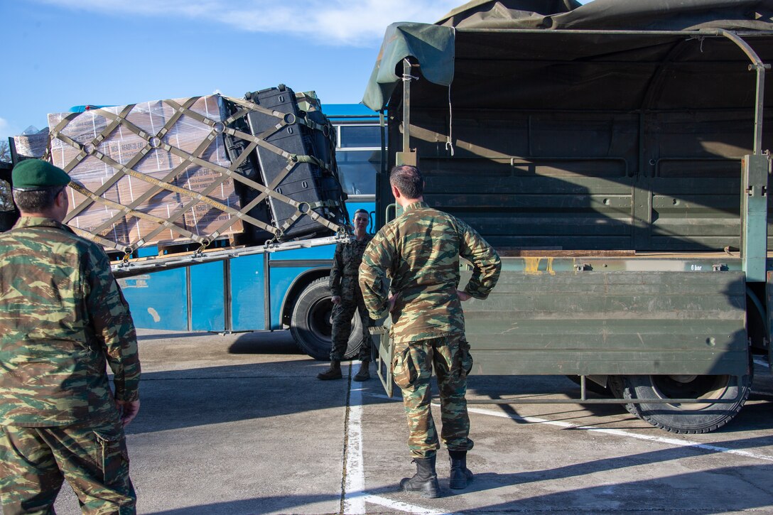 U.S. Marine Corps Chief Warrant Officer 3 Dawn Rooth, a mobility officer with 2nd Marine Regiment, 2nd Marine Division, and Greek Marines with 32nd Marine Brigade, 1st Division load gear during Exercise Alexander the Great 2020 at Larissa Airfield, Greece, Jan. 31, 2020. This exercise conducts integrated battalion-level command and control and company/platoon-level combined arms training to increase interoperability between the U.S. Marine Corps and Hellenic and French Armed Forces, reassure Allied and Partner Nations, improve readiness, reinforce relations, and improve the ability to deploy alongside partnered forces. (U.S. Marine Corps photo by Cpl. Ashley McLaughlin)
