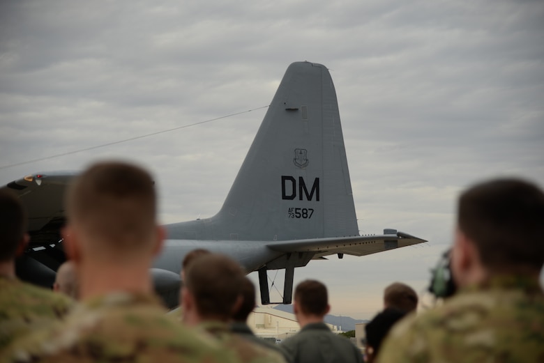 Airmen stand in formation next to an EC-130H