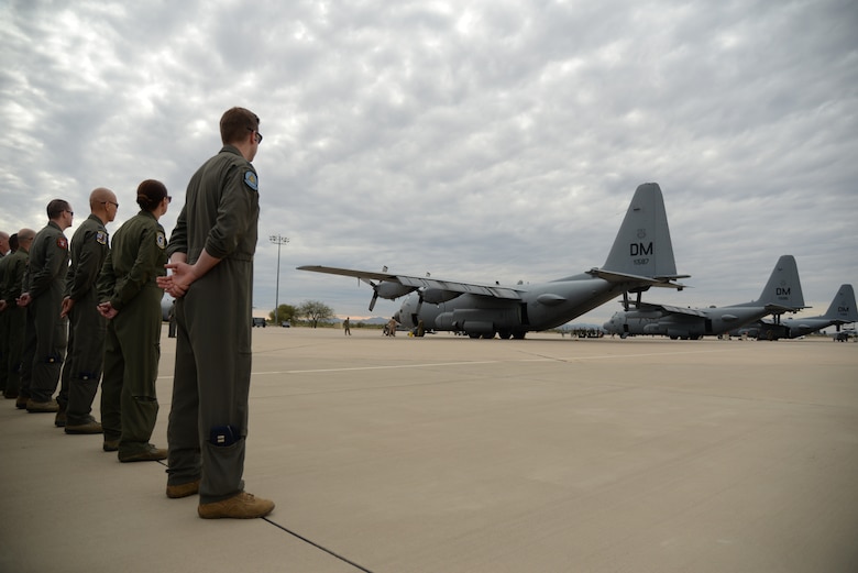 A group of Airmen stand in formation next to an EC-130H