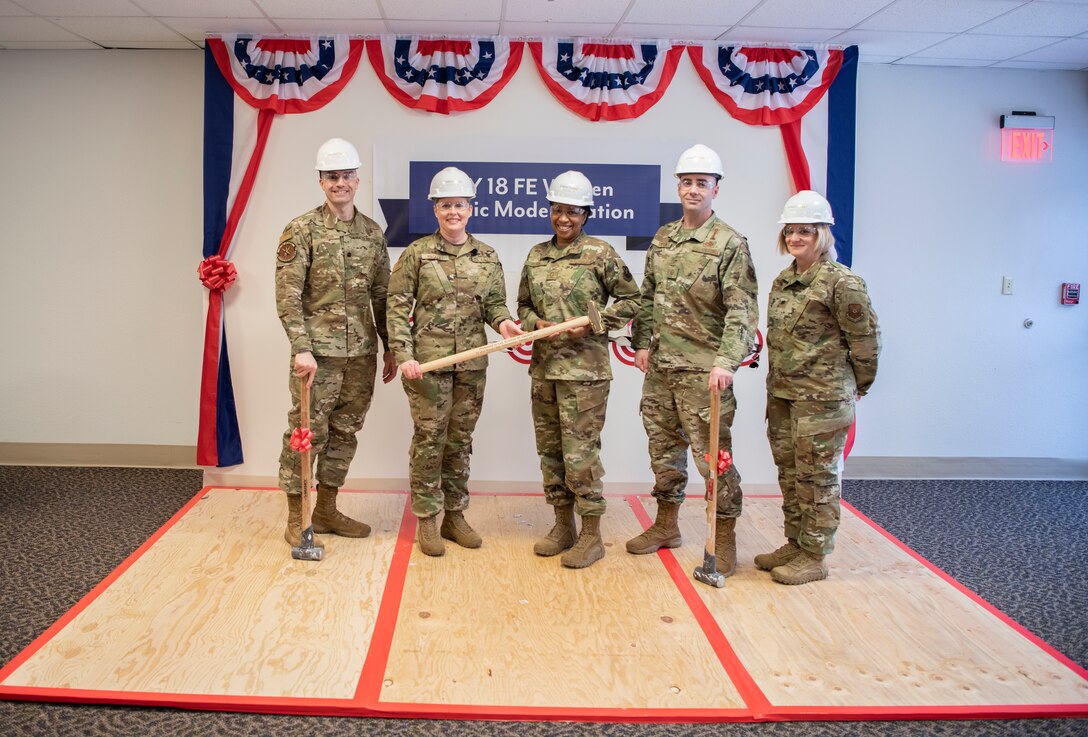 Leadership from the 90th Medical Group stands together holding sledge hammers after the Wall Breaking Ceremony Feb. 10, 2020, at F.E. Warren Air Force Base, Wyo., signifying the start of a three-year clinic modernization project. The first phase of the project will displace several clinics, requing them to work in temporary facilities. (U.S. Air Force photo by Senior Airman Abbigayle Williams)