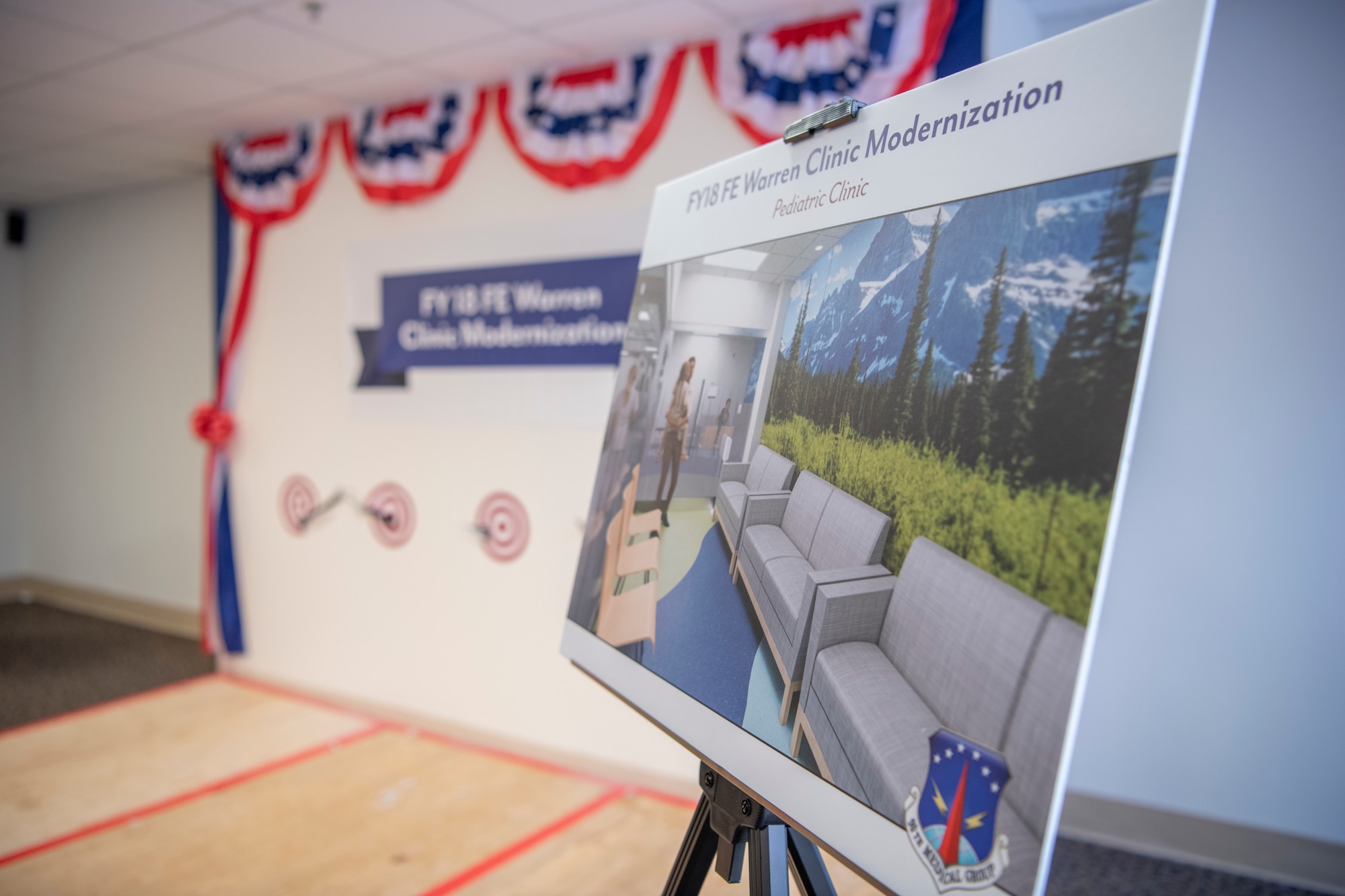 A photo rendering of the remolded clinic sits by the stage during the 90th Medical Group Wall Breaking Ceremony Feb. 10, 2020, at F.E. Warren Air Force Base, Wyo. This rendering and several others will be placed throughout the clinic for patients to view during the three-year modernization project. (U.S. Air Force photo by Senior Airman Abbigayle Williams)