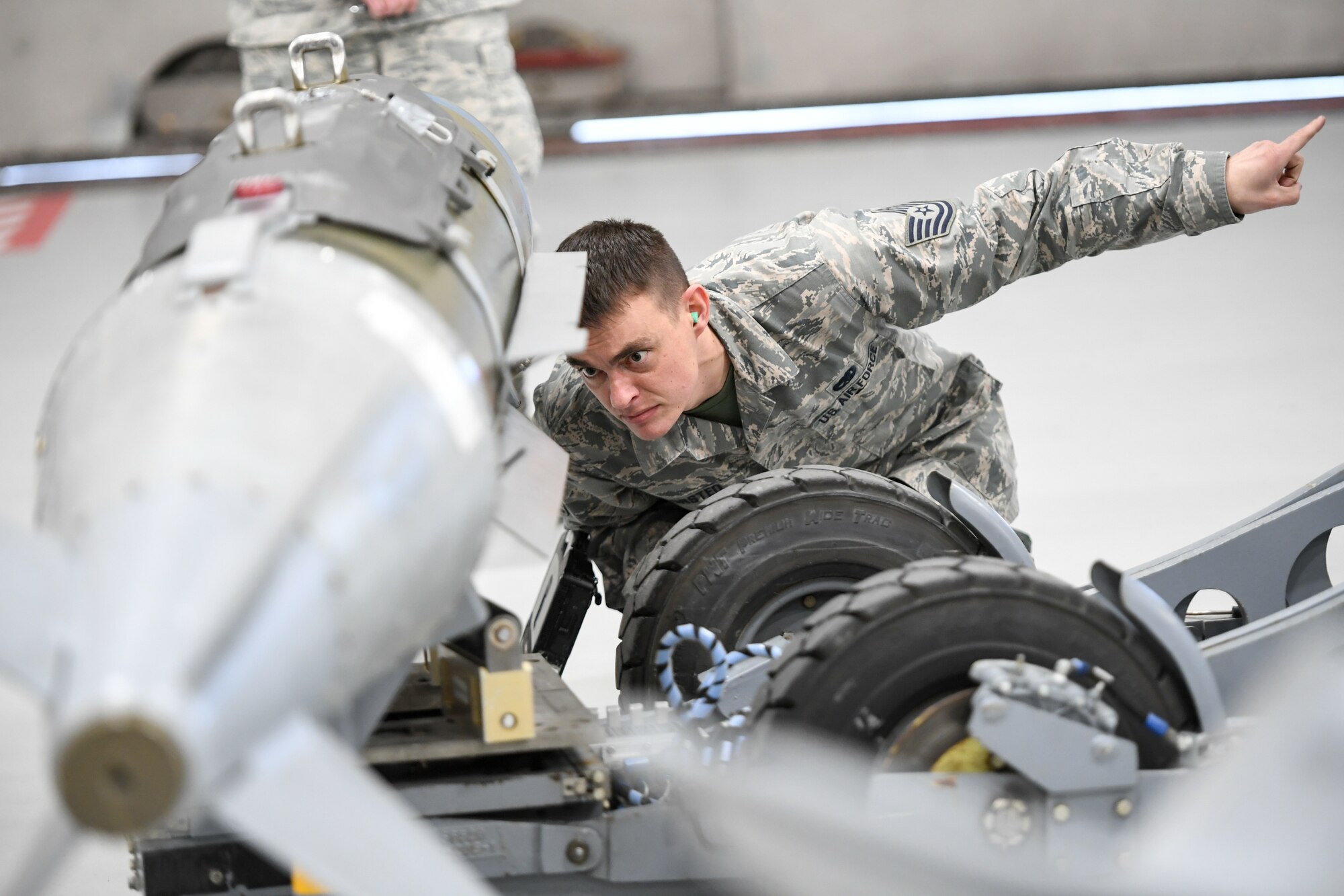 Airman eyes a weapon load onto a lift truck