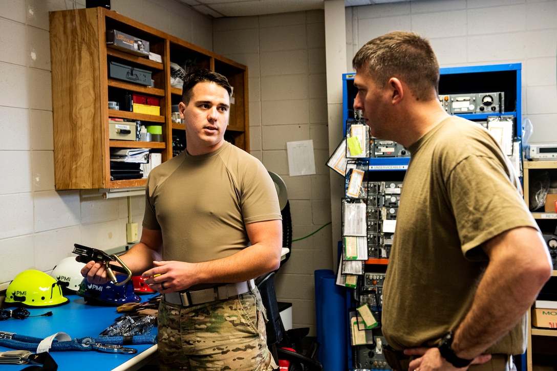 Photo of Airmen discussing climbing equipment.