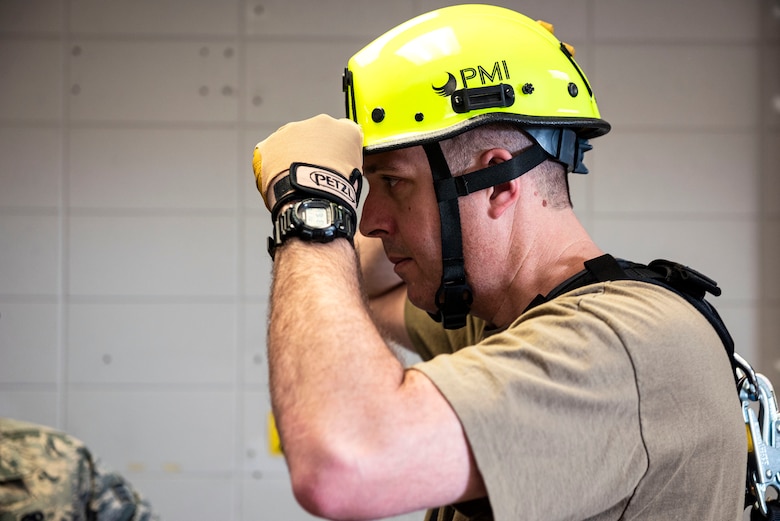 Photo of commander adjusting his climbing helmet.