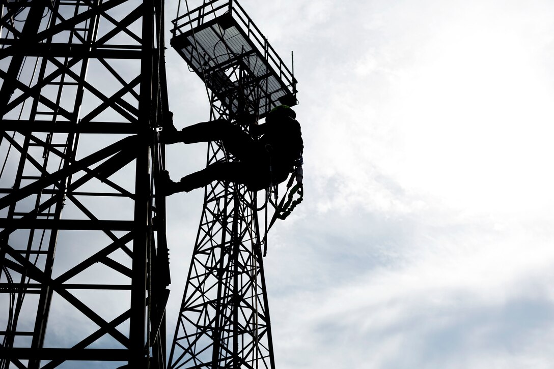 Photo of a commander rappelling down a radio antenna tower.