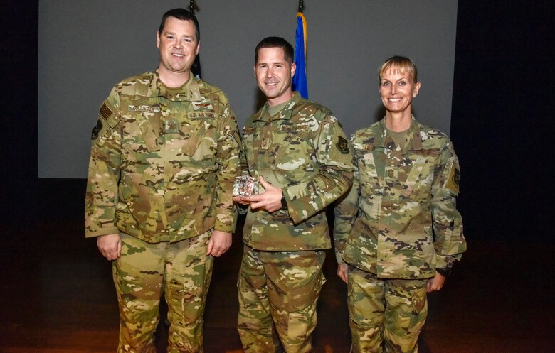 The newly promoted Master Sgt. David Underwood (center), 913th Operations Support Squadron, was selected at the group's non commissioned officer of the 2019 semi-annual award period. Col. Dan Collister (left), 913th Airlift Group deputy commander, and Chief Master Sgt. Kimberly Lord, 913th Airlift Group superintendent, hosted an all call to honor the 2019 award winners on Feb. 8, 2020, at Little Rock Air Force Base, Ark. (U.S. Air Force Reserve photo by Senior Airman Nathan Byrnes)