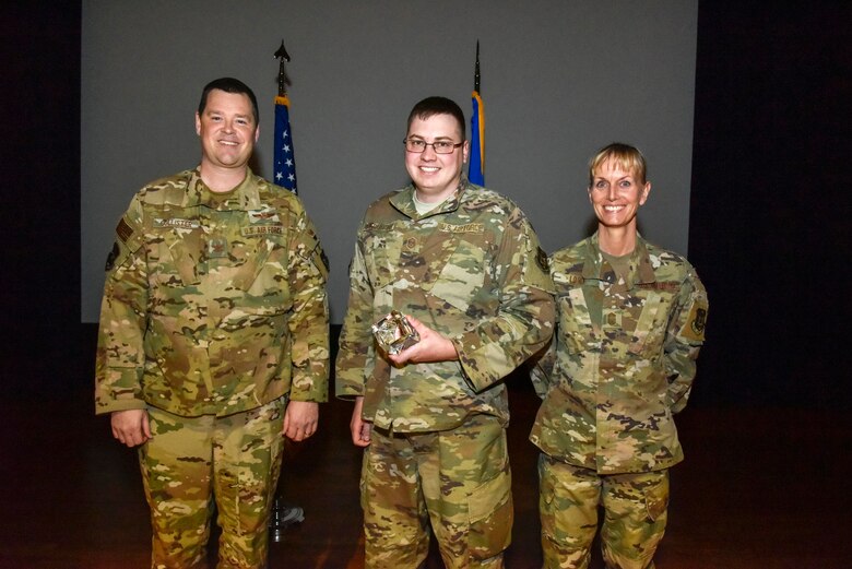 The newly promoted Master Sgt. Kyle Gilbertson (center), 913th Operations Support Squadron, was selected at the group's non commissioned officer of the 2019 semi-annual award period. Col. Dan Collister (left), 913th Airlift Group deputy commander, and Chief Master Sgt. Kimberly Lord, 913th Airlift Group superintendent, hosted an all call to honor the 2019 award winners on Feb. 8, 2020, at Little Rock Air Force Base, Ark. (U.S. Air Force Reserve photo by Senior Airman Nathan Byrnes)