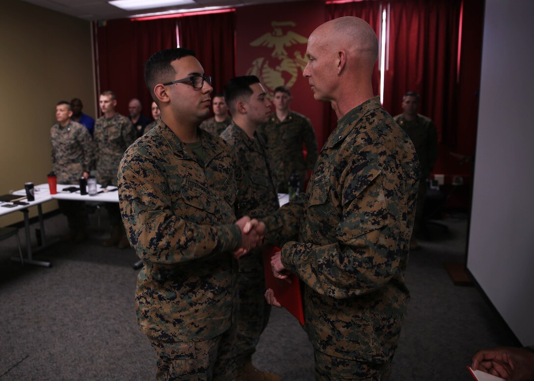 Brigadier General James F. Glynn, commanding general of Marine Corps Recruit Depot Parris Island and the Eastern Recruiting Region, right, shakes hads with Cpl. Jan FloresMartinez, an administrative specialist with 6th Marine Corps District, during an award ceremony at the 6MCD headquarters aboard MCRD Parris Island, South Carolina on Jan. 16, 2020. 6MCD Marines were awarded the Navy Achievement Medals for their outstanding devotion to their duties as administrative specialists. (U.S. Marine Corps photo by Cpl. Jack A. E. Rigsby)