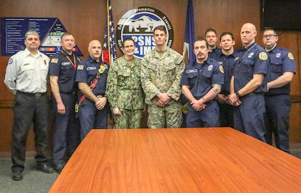 Hospital Corpsman 3rd Class Christopher S. Painter poses Captain Dianna Wolfson, commander of Puget Sound Naval Shipyard & Intermediate Maintenance Facility and with members of the Navy Region Northwest Fire & Emergency Services team after Painter received a Navy and Marine Corps Achievement Medal. Painter received the award for rendering life-saving aid to a PSNS & IMF employee Feb. 7.