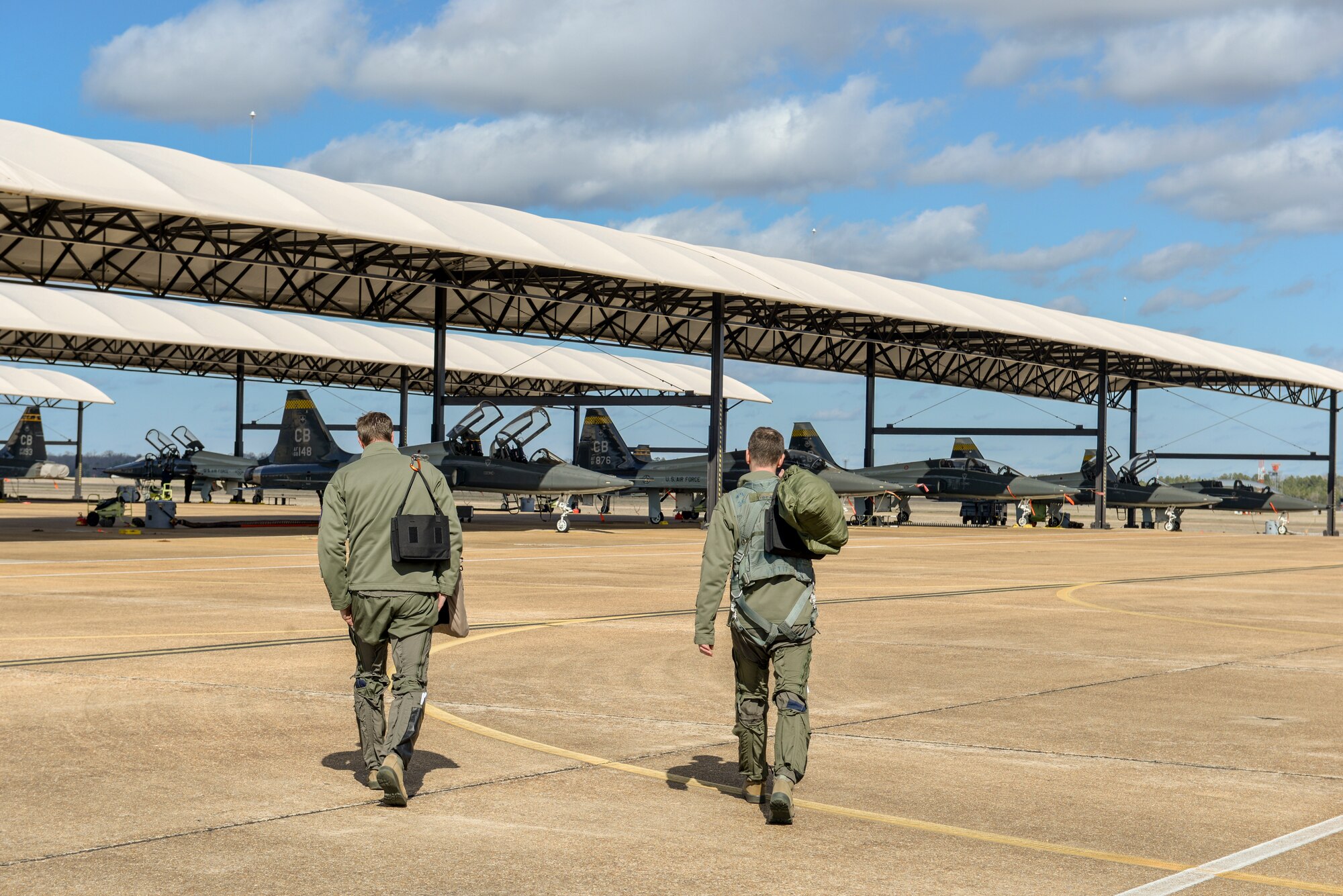 Two pilots from the 49th Fighter Training Squadron walk toward a fleet of T-38 Talons Feb. 7, 2020, at Columbus Air Force Base, Miss. The pilots were participants in exercise Southern Strike, a joint force exercise hosted by the Mississippi Air National Guard. (U.S. Air Force photo by Airman Davis Donaldson)