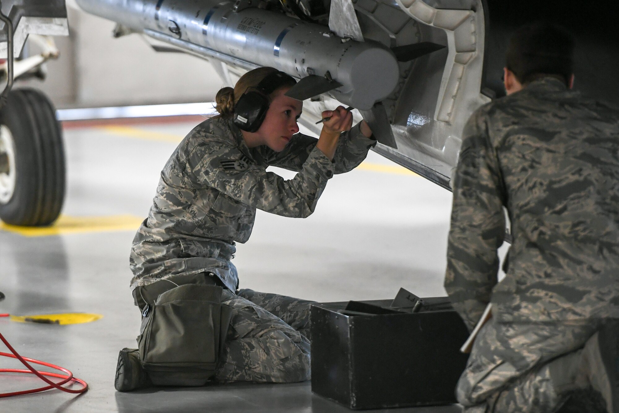 Airman attaches stabilization fins onto an AIM-120 Advanced Medium-Range Air-to-Air Missile