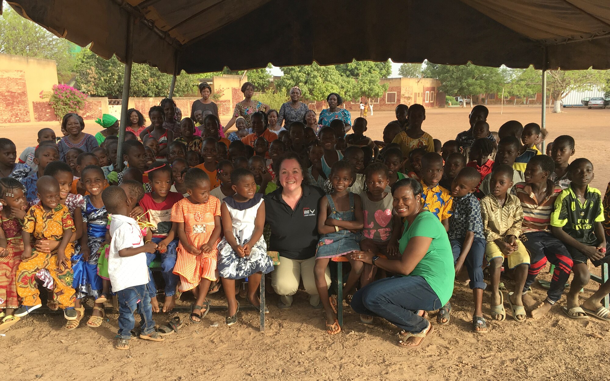 U.S. Air Force Maj. Natosha Reed, U.S. Air Forces in Europe and Air Forces Africa African Partnership Flight mission commander, front right, poses for a photo with children at the SOS Orphanage during a community outreach trip in Burkina Faso, April 19, 2017.