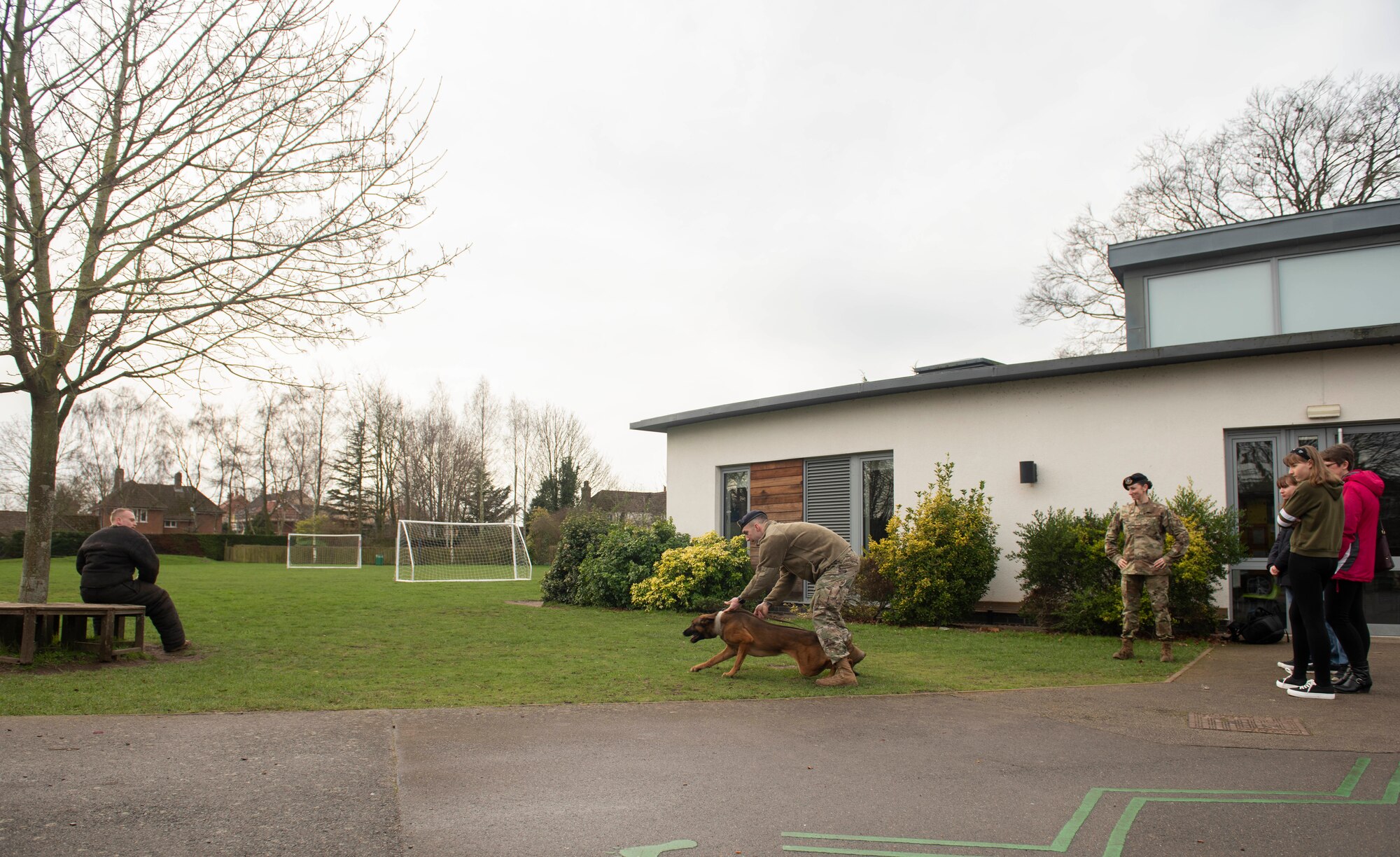 Airmen from 100th Security Forces Squadron military working dog unit show a demonstration with one of the dogs during the Mildenhall police cadets’ open house in Mildenhall, England, Feb. 8, 2020. The Airmen came out to the event to show the cadets and visitors what they do and explain another side of law enforcement. (U.S. Air Force photo by Staff Sgt. Luke Milano)