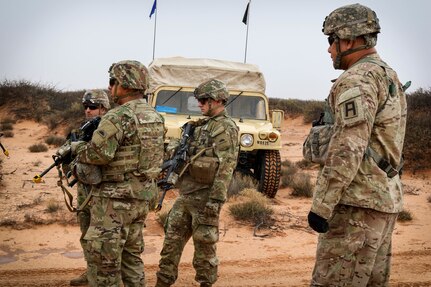 A First Army observer coach/trainer watches as Soldiers of the 2nd Battalion, 162nd Infantry Regiment, 41st Infantry Brigade Combat Team, Oregon National Guard, patrol at Fort Bliss, Texas. The patrols were created by First Army to mirror real life situations the Soldiers will face in Kosovo as part of the Kosovo Force peacekeeping mission.