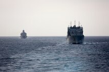 200212-M-OO419-1005 STRAIT OF HORMUZ (Feb. 12, 2020) The amphibious transport dock USS New York (LPD 21), left, and the dry cargo and ammunition ship USNS William McLean (T-AKE12) follow the amphibious assault ship USS Bataan (LHD 5) during a strait transit. Bataan Amphibious Ready Group, with embarked 26th Marine Expeditionary Unit, is deployed to the U.S. 5th Fleet area of operations in support of naval operations to ensure maritime stability and security in the Central Region, connecting the Mediterranean and the Pacific through the Western Indian Ocean and three strategic choke points. (Marine Corps photo by Cpl. Nathan Reyes)