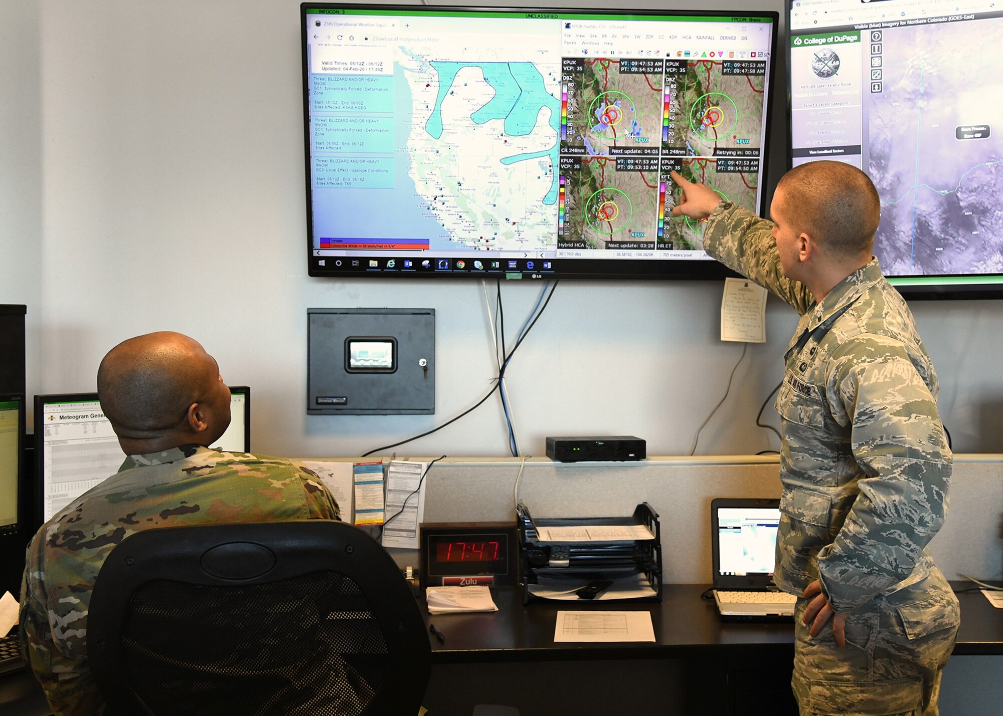 1st Lt. Travis Hodos, 21st Operations Support Squadron weather flight commander, and Master Sgt. Jonathon Winston, 21st OSS weather flight chief, analyze weather forecasts, Jan. 5, 2020 in anticipation of a snow call on Peterson Air Force Base, Colorado. The 10-person weather flight monitors weather conditions around the clock to provide the most accurate and up-to-date information to base leadership. (U.S. Air Force photo by Erica Blanton)