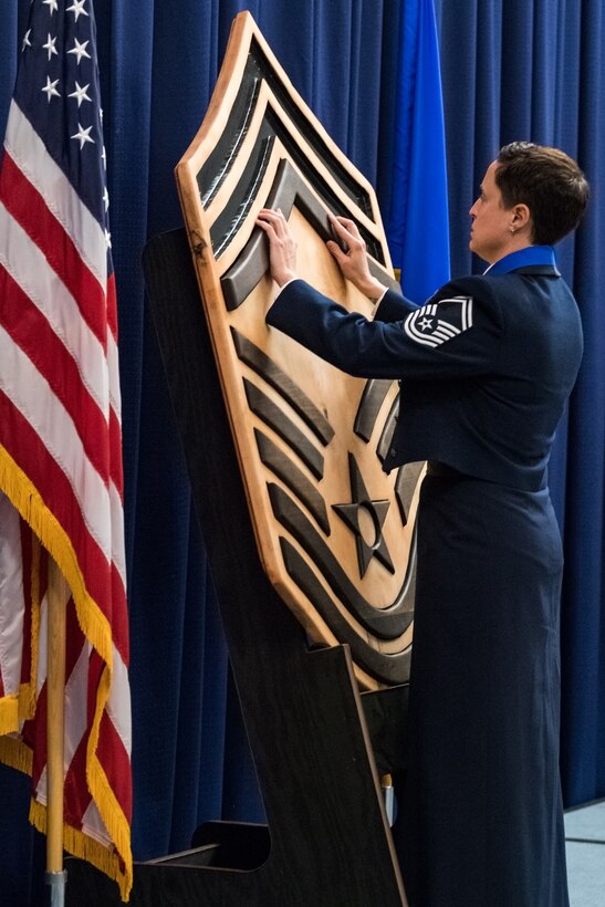 Senior Master Sgt. Georgette Springs, Air Force Mortuary Affairs Operations operations division superintendent, places the master sergeant chevron on the wooden chief’s insignia display during the Chief Master Sergeant Recognition Ceremony at the Landings, Feb. 8, 2020, on Dover Air Force Base, Del. Springs is a chief master sergeant select. (U.S. Air Force photo by Roland Balik)