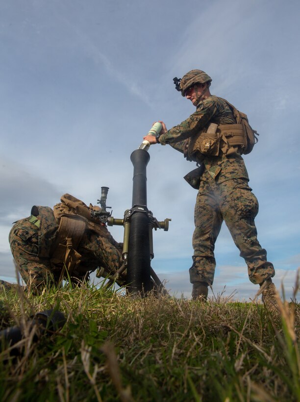 U.S. Marine Corps Cpl. Christian Drumheller, right, a mortarman with 1st Battalion, 2nd Marine Regiment, 2nd Marine Division, loads an M375-series smoke cartridge into an M252 mortar tube during Exercise Fireball Eagle at Marine Corps Air Station Cherry Point, N.C., Feb. 4, 2020. The training consisted of multiple scenarios using aircraft and ground support fire to simulate real warfighting situations. (U.S. Marine Corps photo by Lance Cpl. Brian Bolin Jr.)