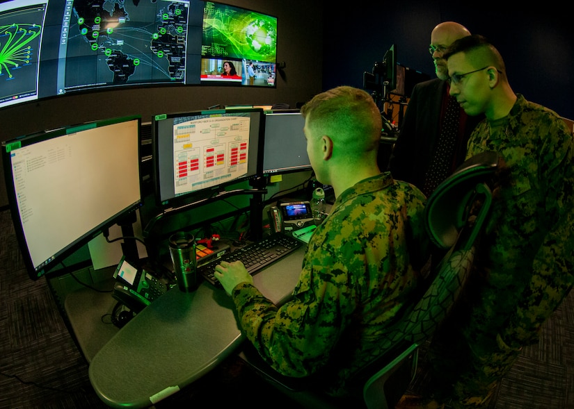 Service members looking at computer screen.