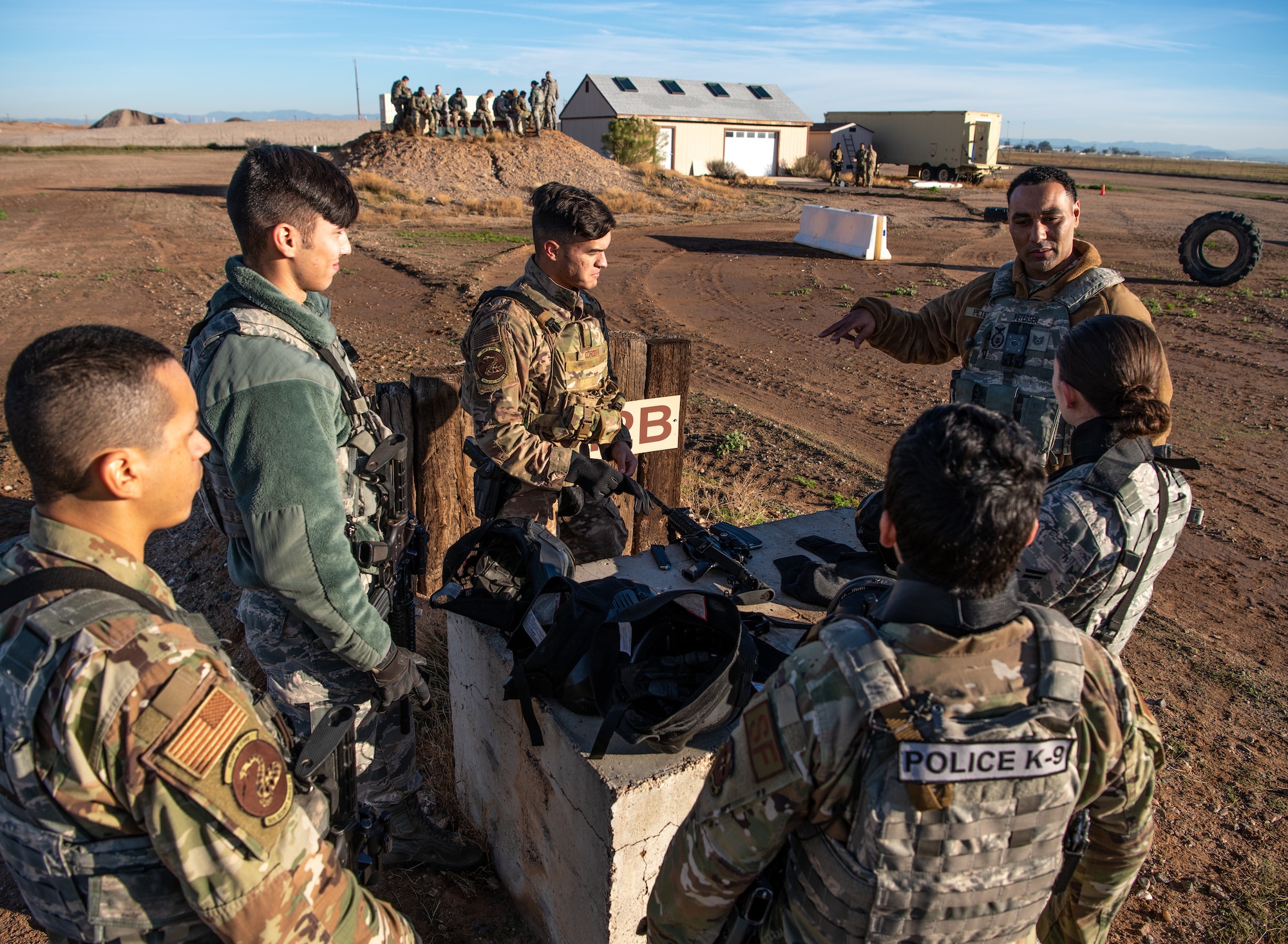 Tech. Sgt. Dominick Peterson (far right), 56th Security Forces Squadron flight instructor, briefs defenders on small unit tactics during Shoot, Move, and Communicate training Dec. 12, 2019, at Luke Air Force Base, Ariz.