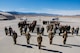 The Airmen of the 42nd Attack Squadron forms a "42" on the flightline in front of two MQ-9 Reapers.