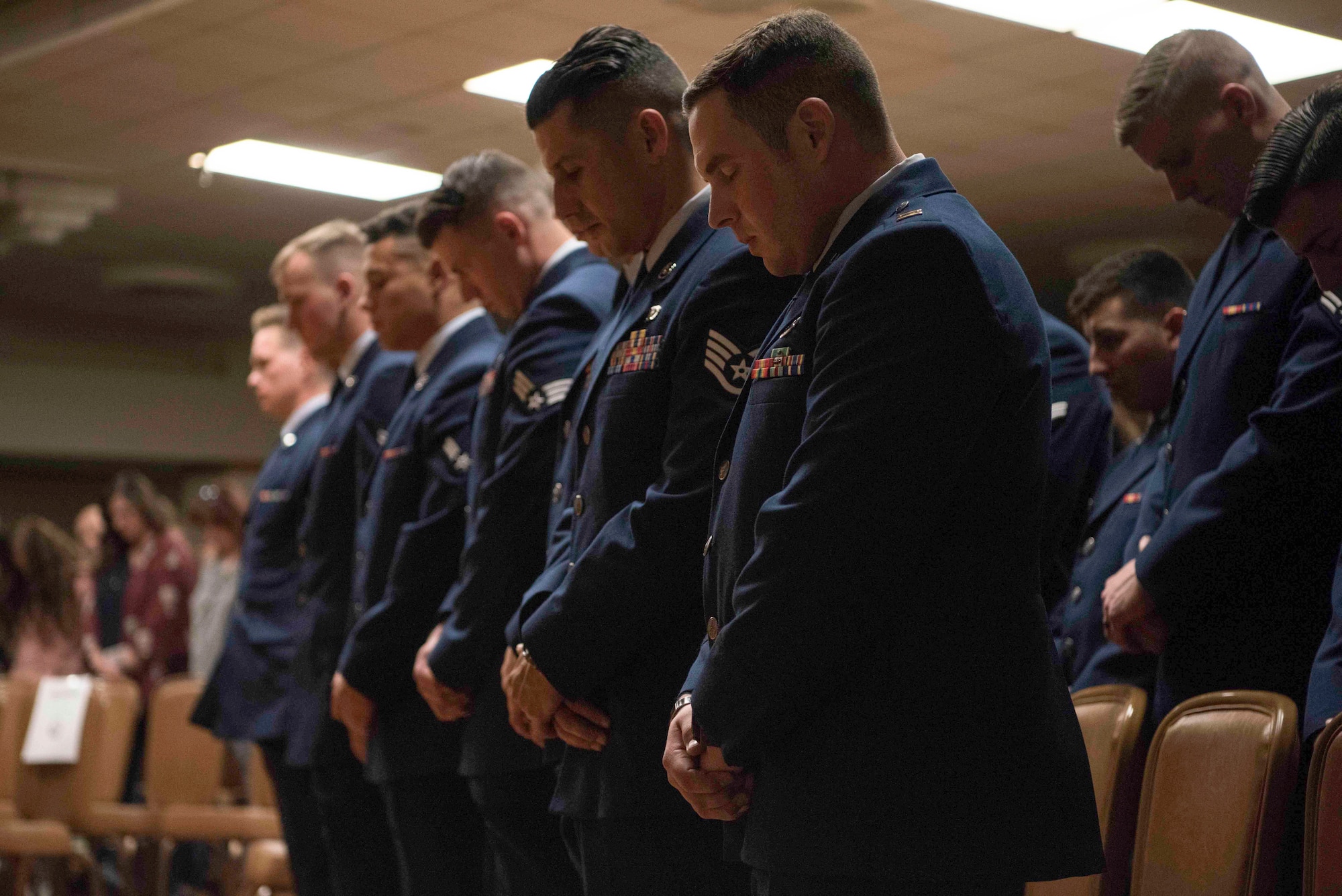 Candidates from Tactical Air Control Party (TACP) Apprentice Course Hawk 110 bow their heads in prayer during graduation at Joint Base San Antonio-Lackland, Texas, Dec. 13, 2019. Chief Master Sgt. Robert L. Zackery III, 47th Flying Training Wing command chief, was the guest speaker for class Hawk 110’s graduation from TACP Apprentice Course. (U.S. Air Force photo by Senior Airman Marco A. Gomez)