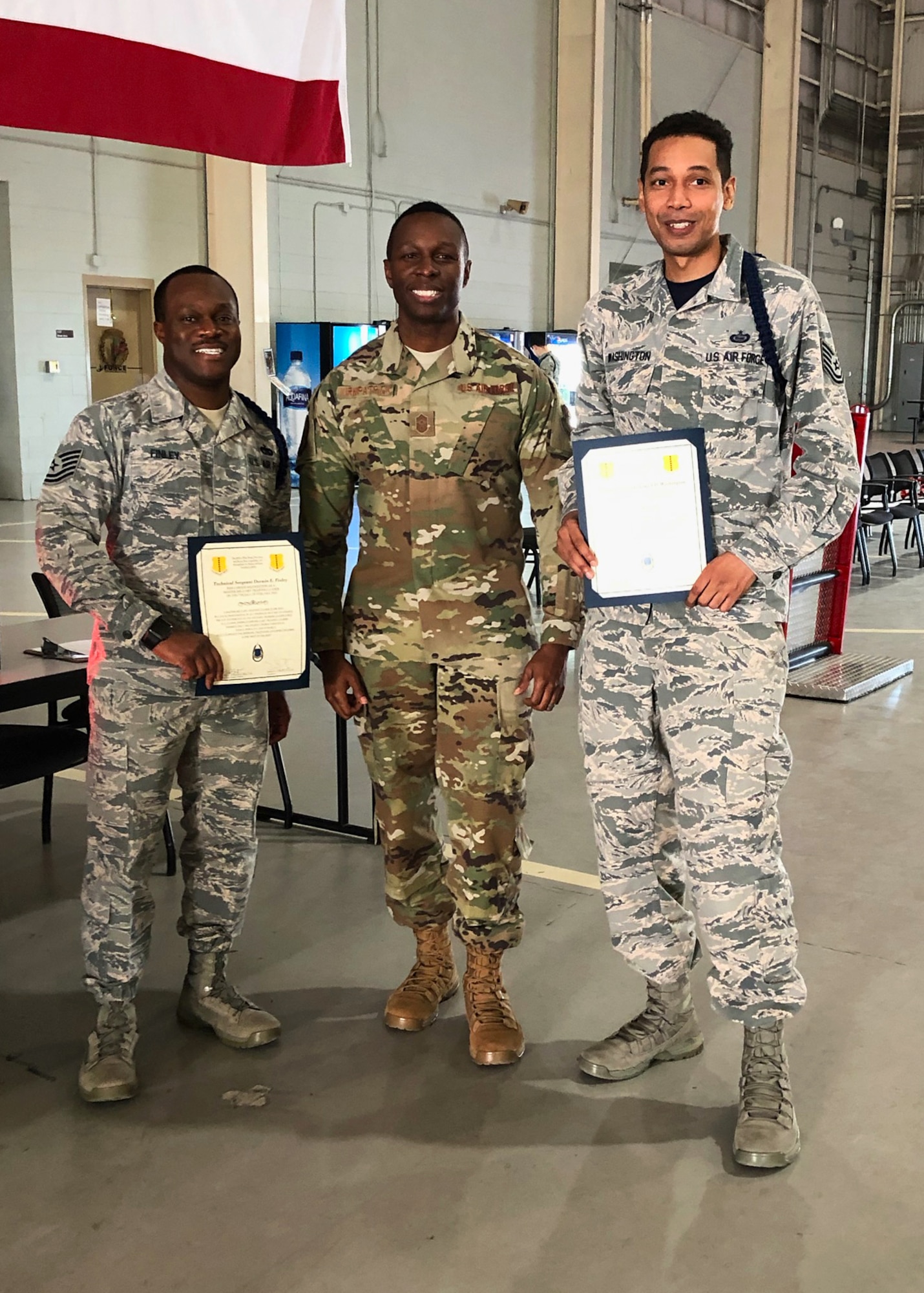 U.S. Air Force Tech. Sgt. Derwin Finley, 312th Training Squadron assistant flight chief and master military training leader, Chief Master Sgt. Lavor Kirkpatrick, 17th Training Wing command chief and Tech. Sgt. Joseph Washington, 315th Training Squadron assistant flight chief and master MTL pose for a congratulatory photo in the Louis F. Garland Department of Defense Fire Academy High Bay on Goodfellow Air Force Base, Texas, Feb. 7, 2020.  Finley and Washington became the first Master Military Training Leaders in the Air Education and Training Command. (Courtesy photo)