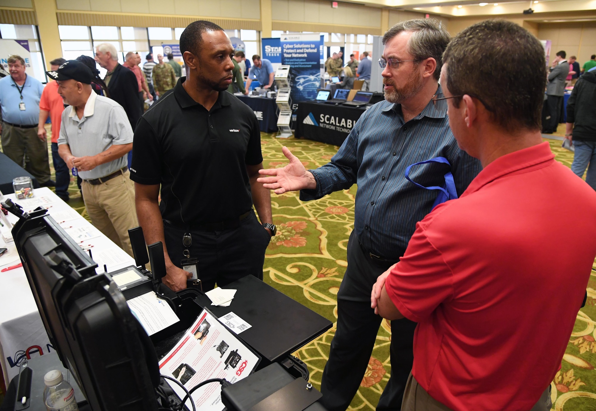 J.J. Starnes, 81st Training Support Squadron curriculum development manager, asks Edward Triche, III, Verizon Wireless solutions architect manager, about the capabilities of the mobile command center on display as Mark Jegel, 81st TRSS curriculum development manager, stands by during the Annual Keesler Air Force Base Tech Expo inside the Bay Breeze Event Center at Keesler Air Force Base, Mississippi, Feb. 11, 2020. The expo, hosted by the 81st Communications Squadron, was held to introduce military members to the latest in technological advancements to bolster the Air Force�s capabilities in national defense. (U.S. Air Force photo by Kemberly Groue)