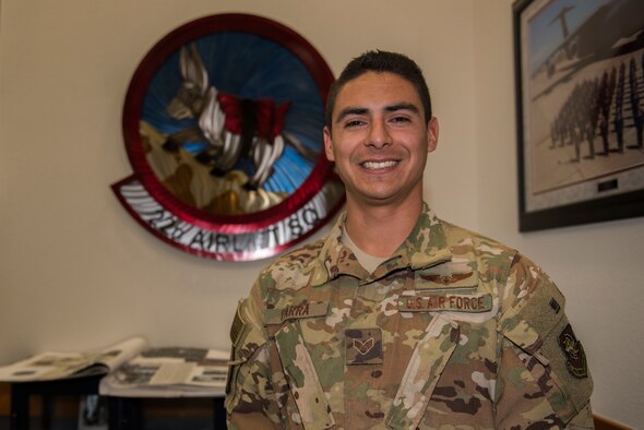 U.S. Air Force Senior Airman Brian Parra, 22nd Airlift Squadron C-5M Super Galaxy flight engineer, stands in front of the 22nd AS emblem Feb. 11, 2020, at Travis Air Force Base, California. Parra was the Warrior of the Week from Feb. 9 - 15. The program recognizes Airmen who have made significant contributions to their units. (U.S. Air Force photo by Airman 1st Class Cameron Otte)