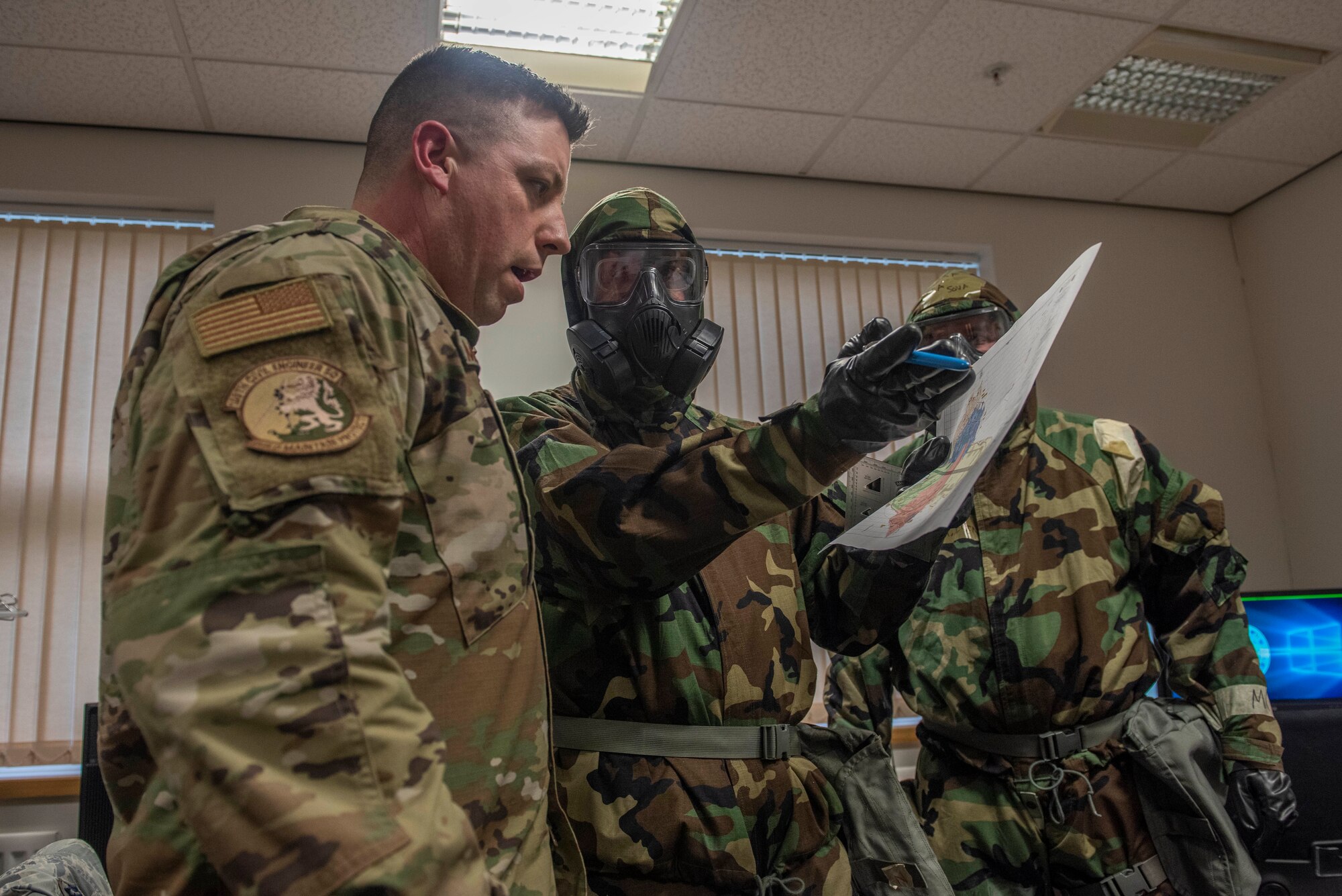 Master Sgt. James McGarvey, 100th Civil Engineer Squadron emergency management section chief, discusses chemical, biological, radiological, nuclear and explosive procedures during a readiness exercise at RAF Mildenhall, England, Feb. 10, 2020. The main purpose of the exercise was to demonstrate how rapidly Bloody Hundredth Airmen are able to organize an entire wing and deal with simulated real-world scenarios. (U.S. Air Force photo by Staff Sgt. Luke Milano)