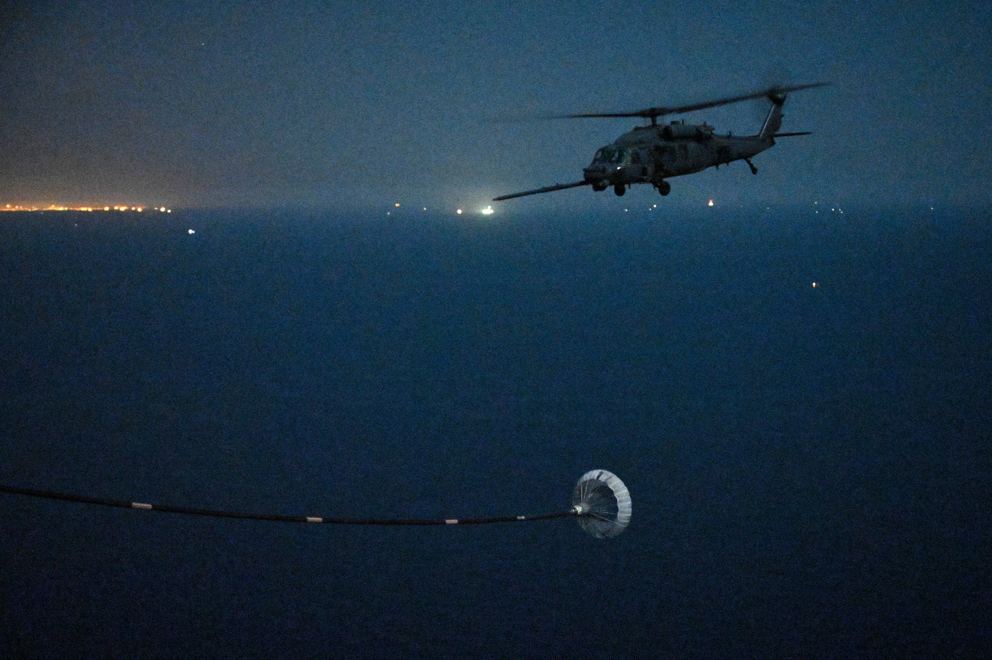A U.S. Air Force HH-60G Pave Hawk assigned to the 66th Expeditionary Rescue Squadron, deployed to Al Udeid Air Base, Qatar, flies over the Arabian Gulf as it prepares to conduct a helicopter in-air refueling with a U.S. Air Force HC-130J Combat King II assigned to the 79th ERQS, deployed to AL Udeid AB, Feb. 6, 2020.