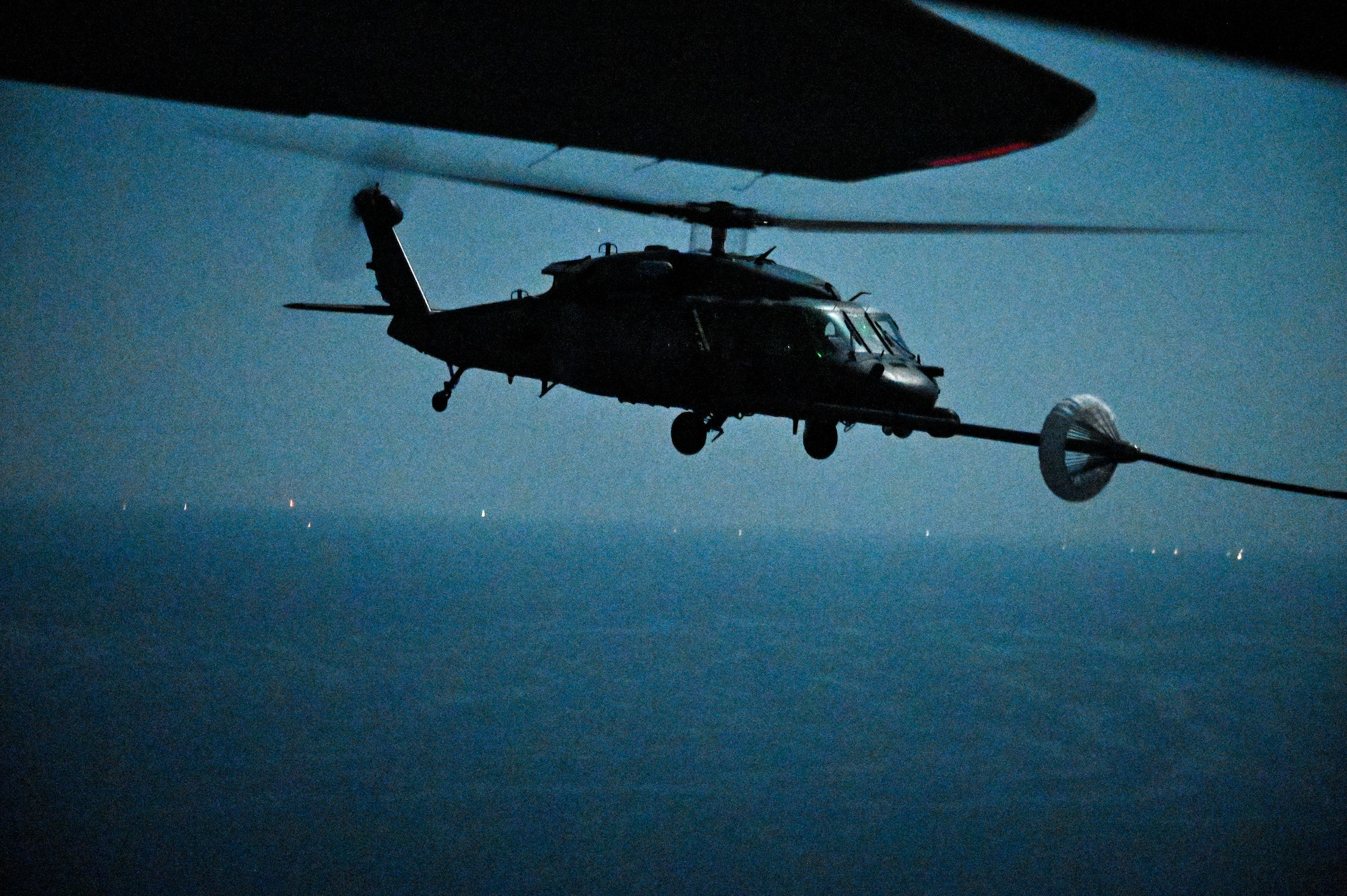A U.S. Air Force HH-60G Pave Hawk, assigned to the 66th Expeditionary Rescue Squadron deployed to Al Udeid Air Base, Qatar, conducts a helicopter in-air refueling over the Arabian Gulf with a U.S. Air Force HC-130J Combat King II, assigned to the 79th ERQS deployed to Al Udeid AB, Feb. 6, 2020.