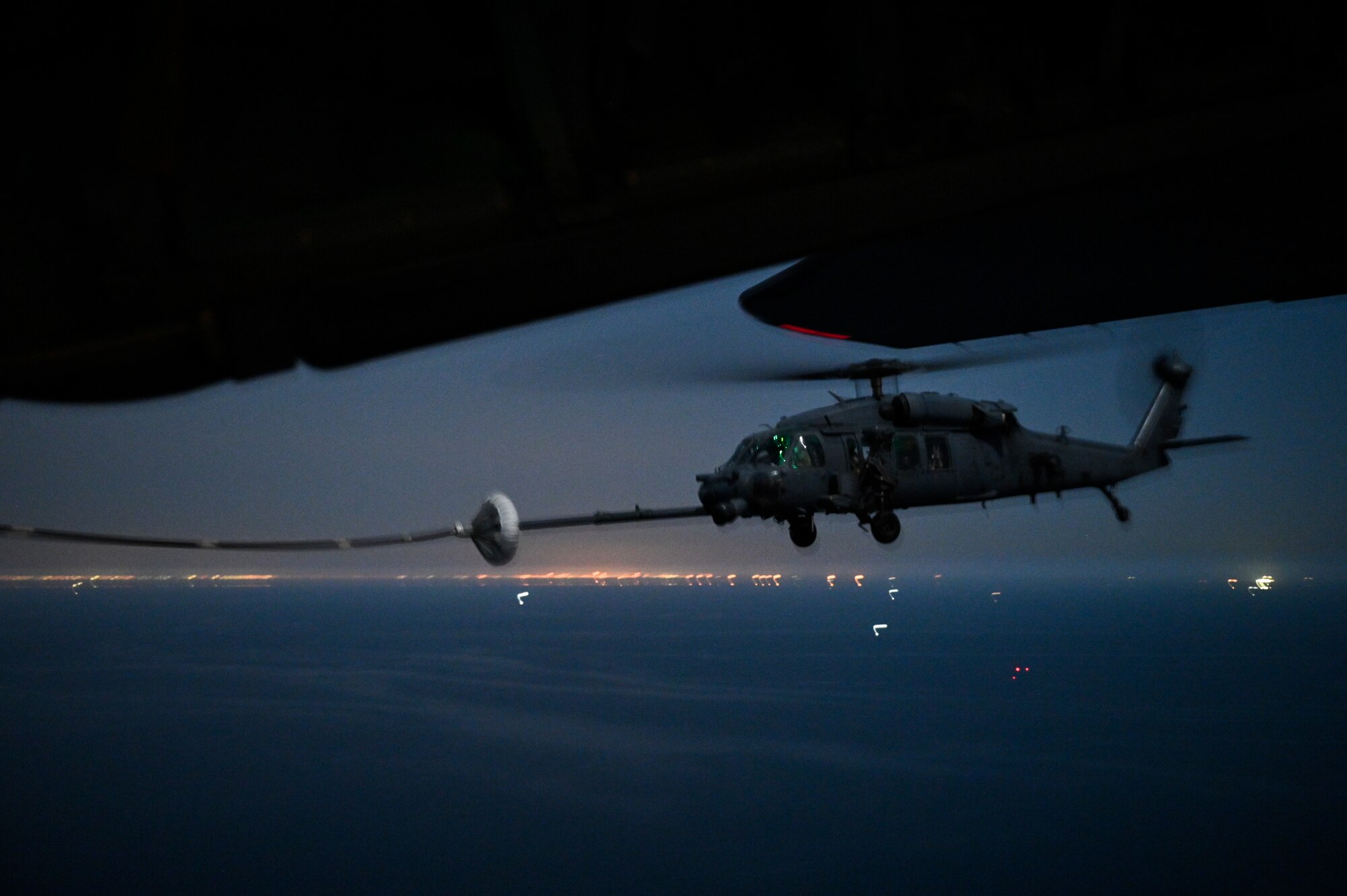 A U.S. Air Force HH-60G Pave Hawk, assigned to the 66th Expeditionary Rescue Squadron deployed to Al Udeid Air Base, Qatar, conducts a helicopter in-air refueling over the Arabian Gulf with a U.S. Air Force HC-130J Combat King II, assigned to the 79th ERQS deployed to Al Udeid AB, Feb. 6, 2020.