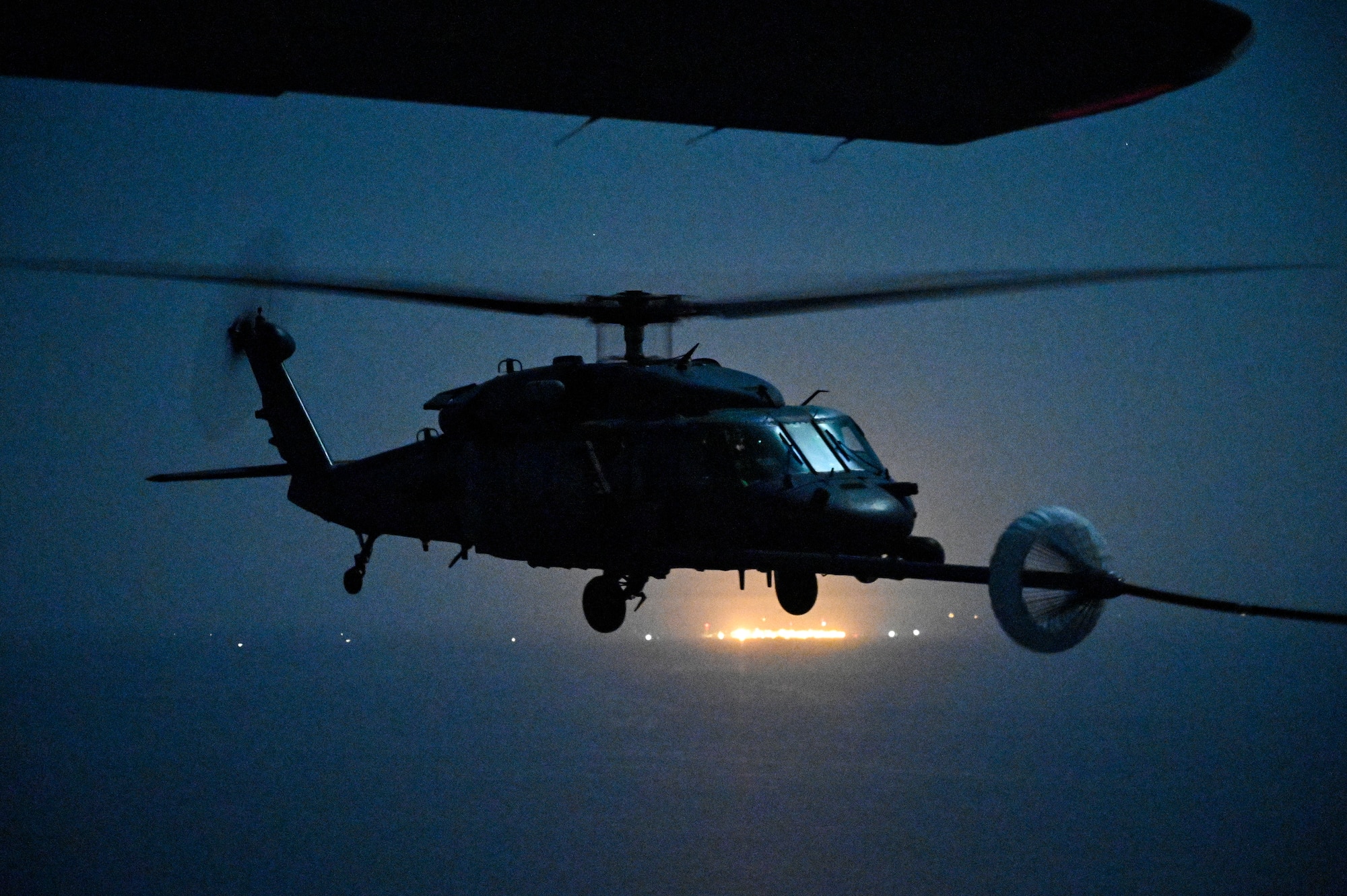 A U.S. Air Force HH-60G Pave Hawk, assigned to the 66th Expeditionary Rescue Squadron deployed to Al Udeid Air Base, Qatar, conducts a helicopter in-air refueling over the Arabian Gulf with a U.S. Air Force HC-130J Combat King II, assigned to the 79th ERQS deployed to Al Udeid AB, Feb. 6, 2020.