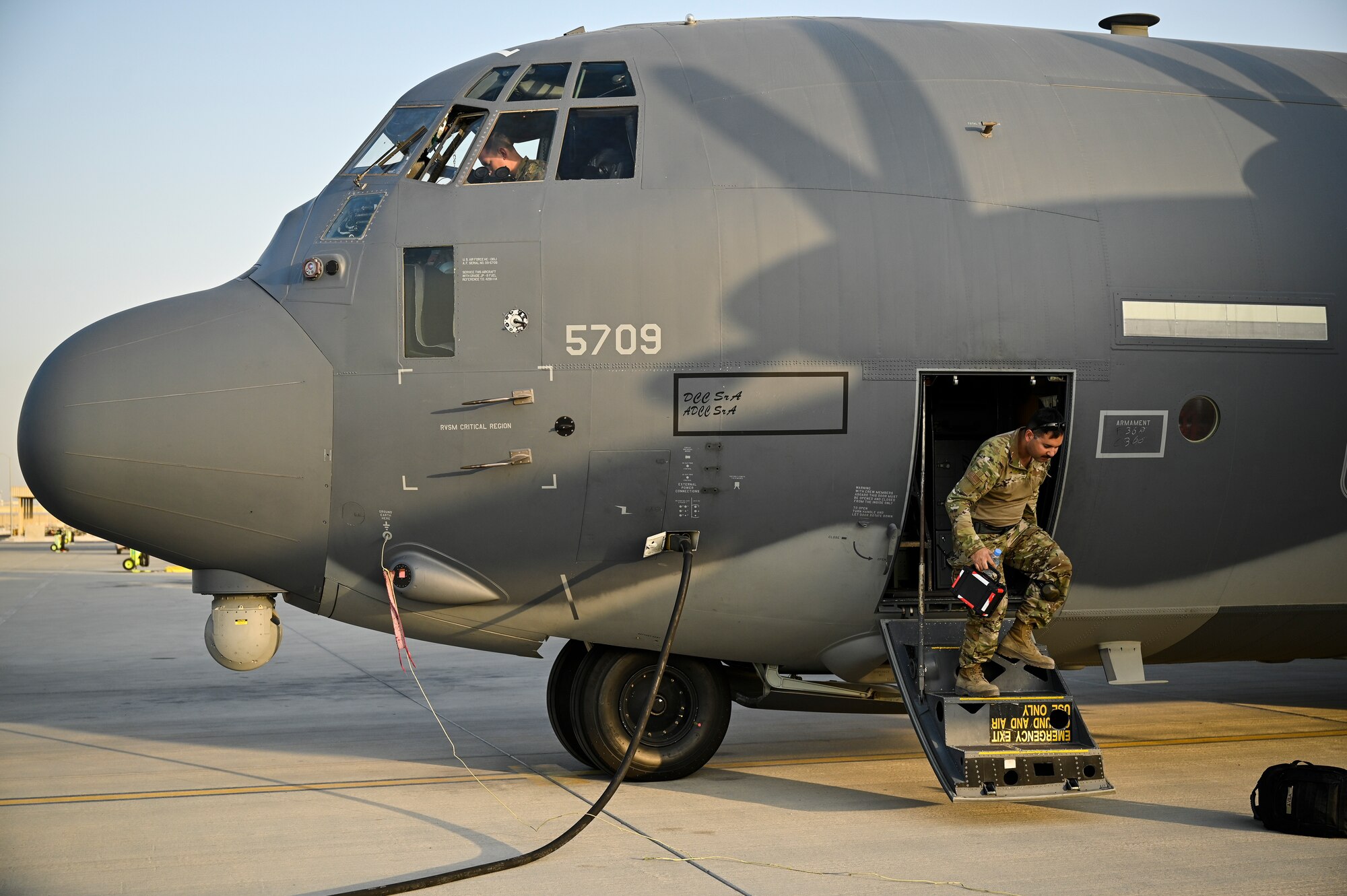 A U.S. Air Force HC-130J Combat King II crew chief and aircrew with the 79th Expeditionary Rescue Squadron, deployed to Al Udeid Air Base, Qatar, wait to launch a Combat King II before a personnel recovery training mission at Al Udeid AB, Feb. 6, 2020.