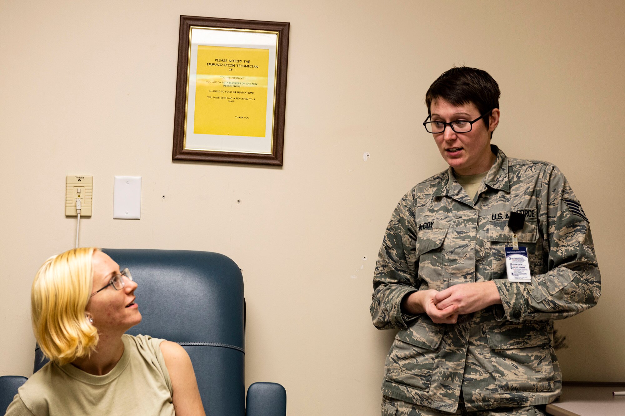 Photo of an immunizations technician briefing an Airman.