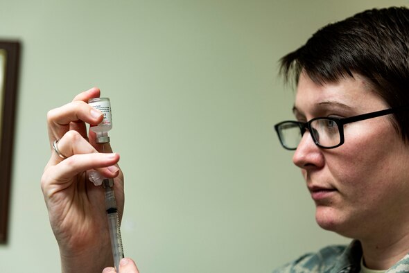 Photo of an immunizations technician drawing vaccination fluid.