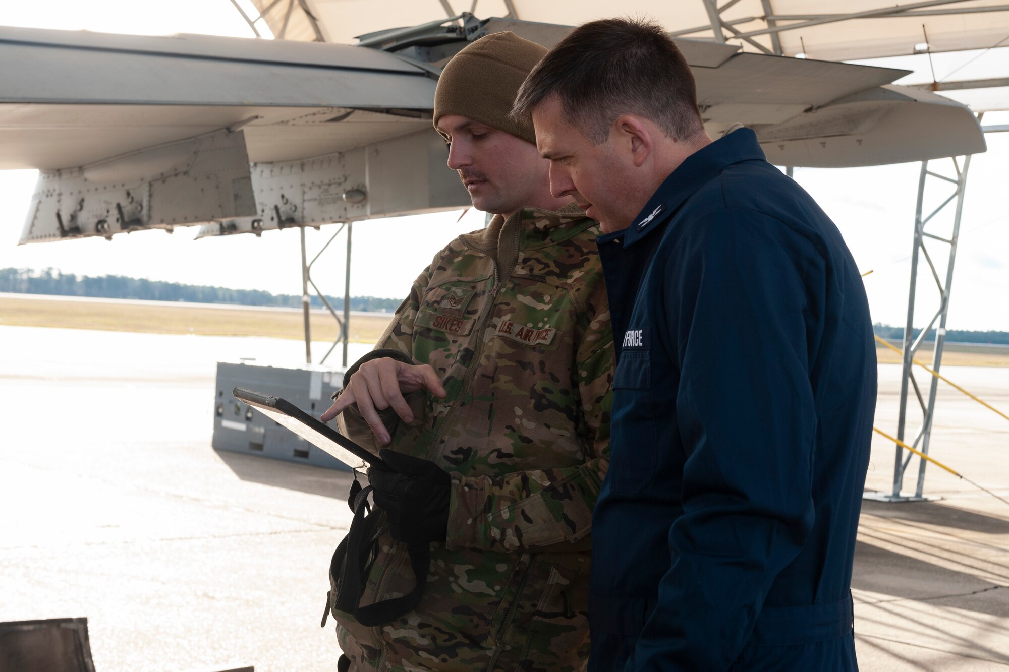 Photo of Airman explaining a technical order to Col. Walls