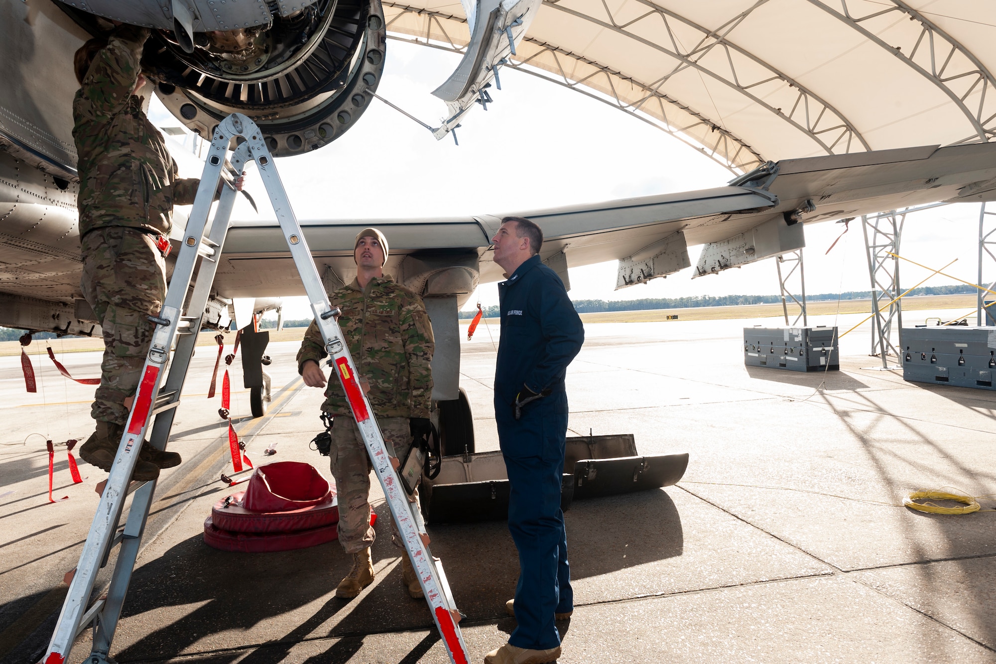 Photo of Airmen showing Col. Walls an engine